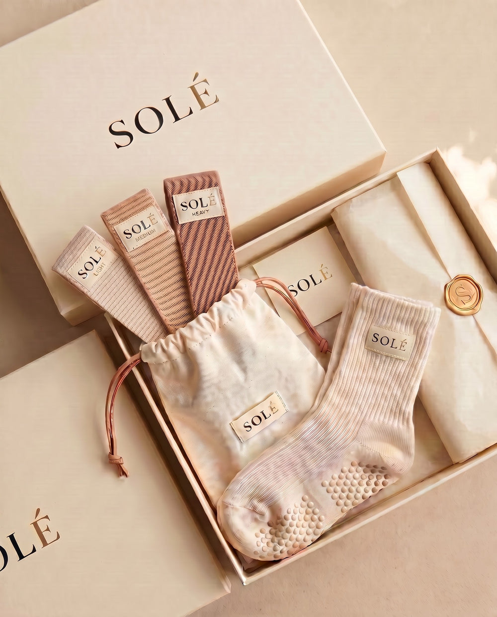 The SOLÉ Starter Kit gift box — cream grip socks paired with the three-band resistance set