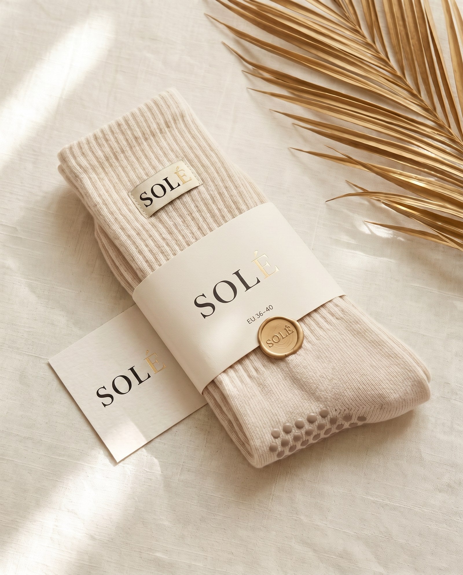 SOLÉ grip socks in warm nude tones, laid flat in soft daylight